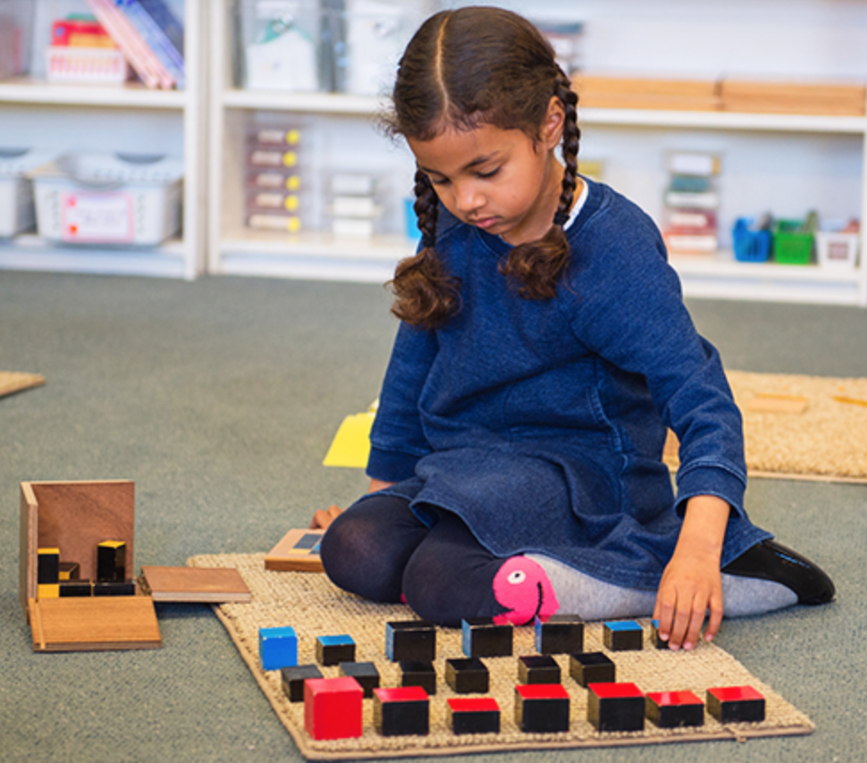 Child playing on the floor with Montessori toys